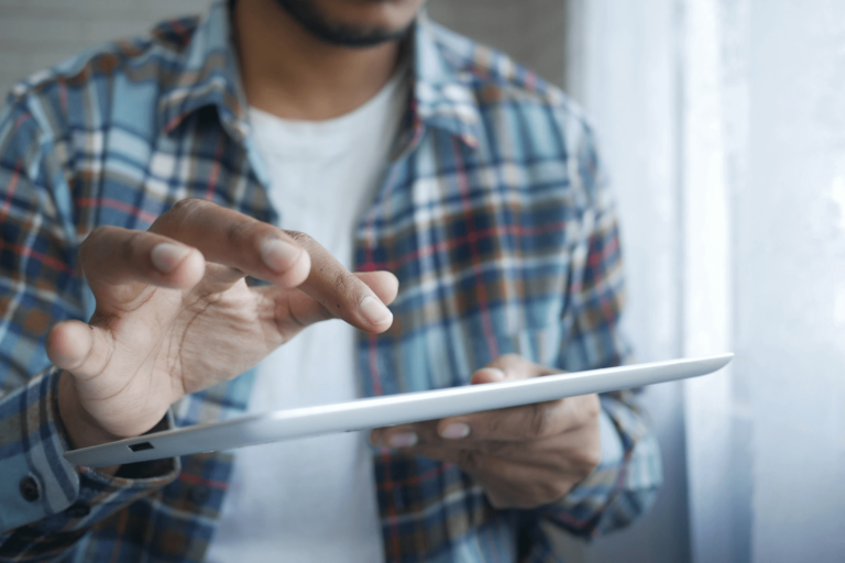 Photo of a man with a blouse operating an AI tablet